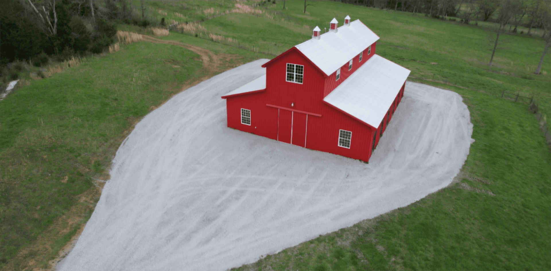 Finished driveway and site prep around a red barn